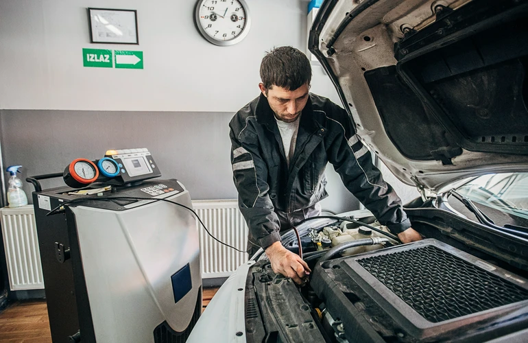 mechanik, który sprawdza  klimatyzację w samochodzie