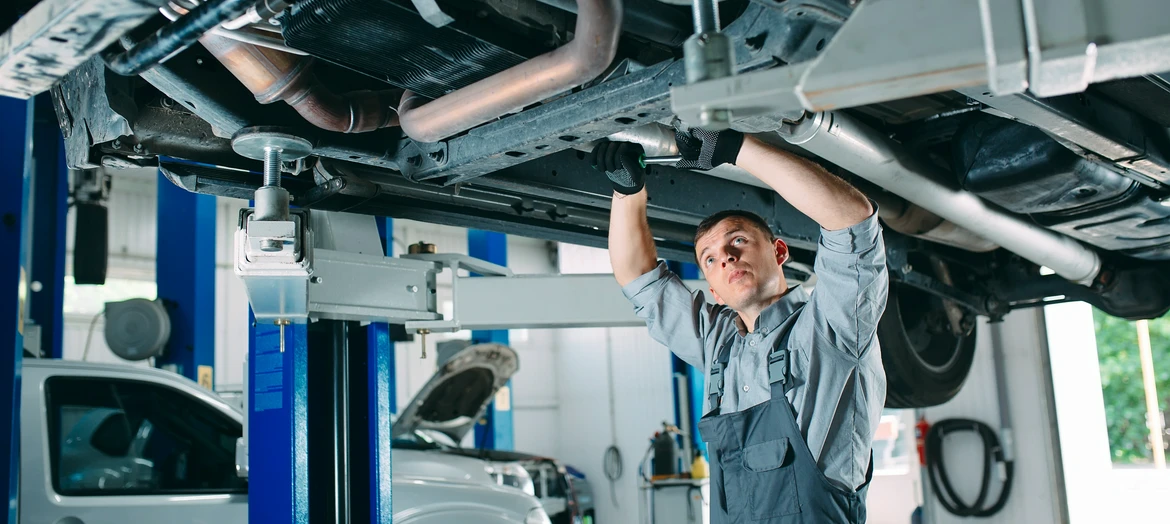 mechanik naprawiając podwozie auta